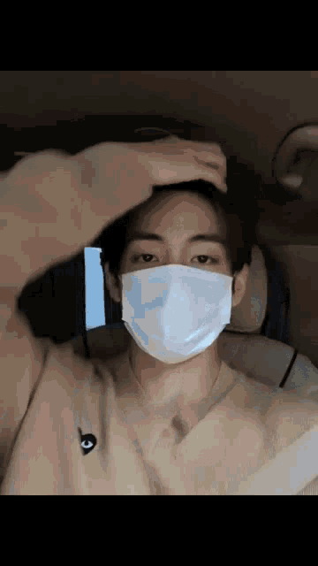 a man wearing a mask is sitting in a car .