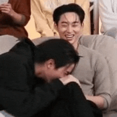 a group of men are sitting on a couch laughing and talking to each other .