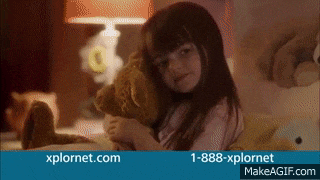 a little girl is hugging a teddy bear on a bed with the website xplornet.com in the background