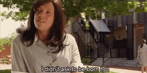 a woman in a wig says i did n't ask to be born hot in front of a building .