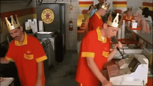 a group of men wearing crowns are working at a burger king
