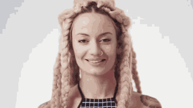a woman with dreadlocks and a nose ring smiles
