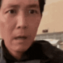 a man with a surprised look on his face is looking at the camera .