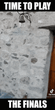 a stone wall with a bell on it and the words time to play the finals below it