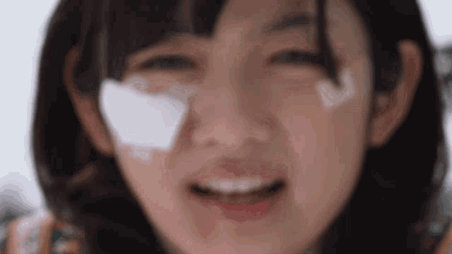a close up of a woman 's face with a bandage on her nose