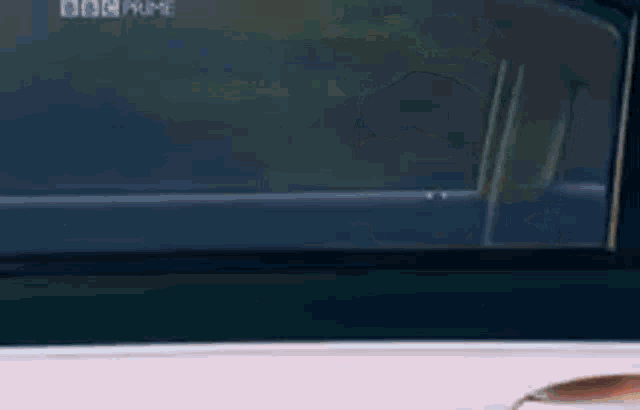a man is looking out the window of a car with bbc prime written on it