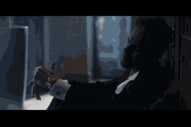 a man and a woman are looking at each other in a dark room