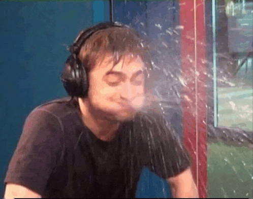 a man wearing headphones is splashing water on his face