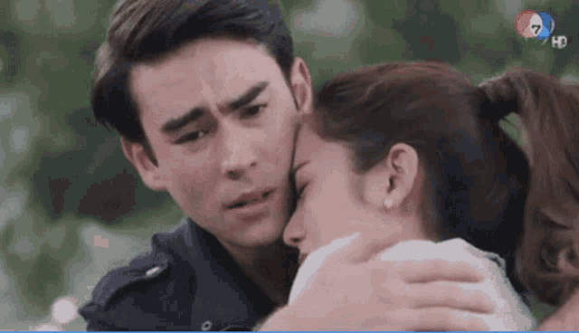 a man and a woman are hugging each other in front of a screen that says 7 hd
