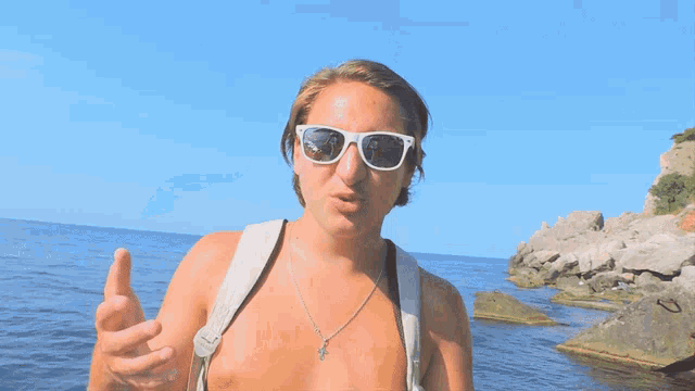 a woman wearing sunglasses and a necklace with a cross