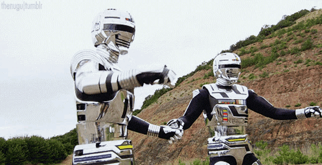 a couple of robots standing next to each other with a watermark that says tumblr