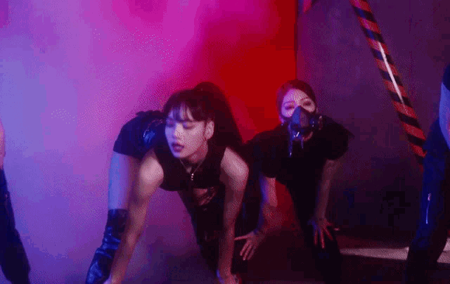 a woman wearing a gas mask is dancing in front of a red wall
