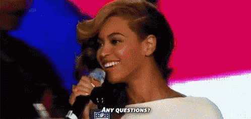 a woman is holding a microphone in her hand and smiling while asking any questions .