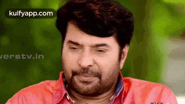 a man with a beard is wearing a red shirt