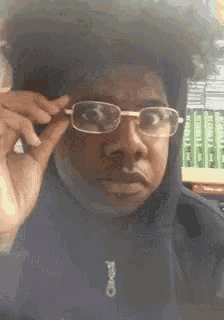 a young man wearing glasses and a black jacket with the word calvin klein on it