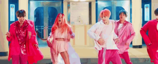 a group of people are standing next to each other in pink clothes .