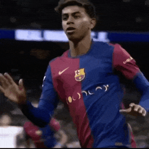 a soccer player wearing a blue and red jersey with the word fcb on it