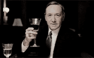 a woman is holding a glass of wine in her hand .
