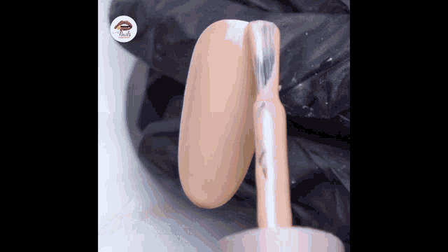 a bottle of nail polish is being applied to a nail .