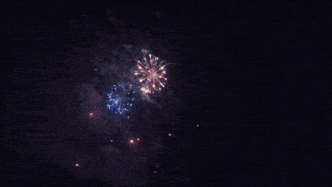 a blue and white fireworks display in the dark sky