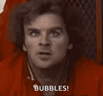 a man in a red shirt is sitting in a chair and says `` bubbles '' .