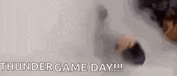 a man is standing in a cloud of smoke with the words `` thundergame day '' written on it .