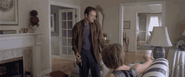 a man and woman are standing in a living room .