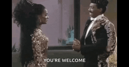a man in a tuxedo and a woman in a dress are standing next to each other and holding hands .