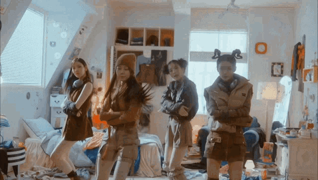 a group of girls are standing in a messy room with a clock on the wall