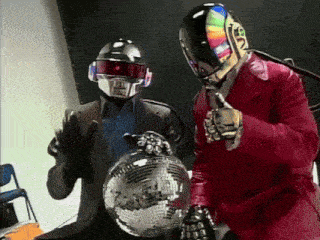 a man in a red suit holds a disco ball next to a man in a black helmet