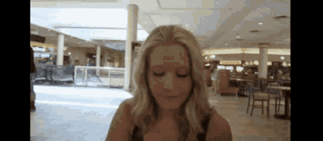 a woman with a bandage on her forehead looks at the camera