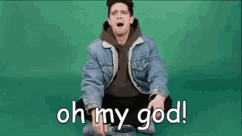 a man in a denim jacket is sitting on the floor with his mouth open and the words `` oh my god '' written next to him .