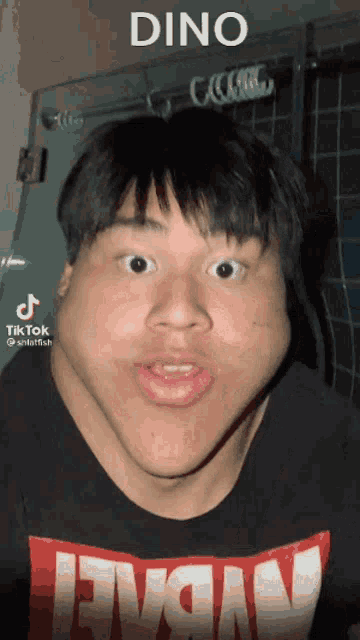 a man wearing a t-shirt that says levis is making a funny face