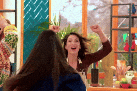 a woman with her arms in the air is smiling