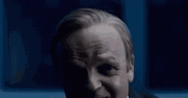 a close up of a man in a suit and tie making a funny face .