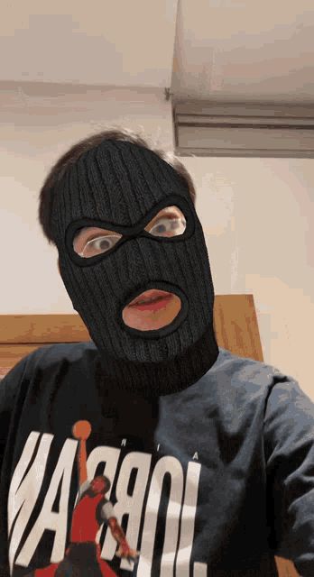 a man wearing a ski mask and a t-shirt that says ' warriors '