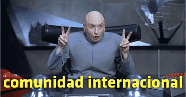 a bald man giving a peace sign with the words comunidad internacional below him