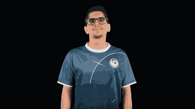 a man wearing glasses and a blue shirt with the letter g on the front