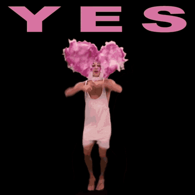 a man with a pink heart on his head stands in front of the word yes