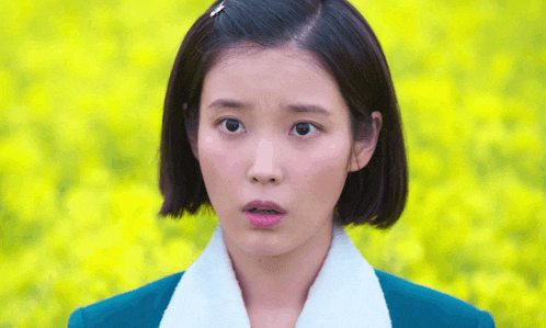 a woman with a surprised look on her face is wearing a green jacket