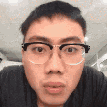 a man wearing glasses is making a funny face .
