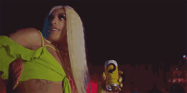 a woman in a green top is holding a yellow can with the letter r on it