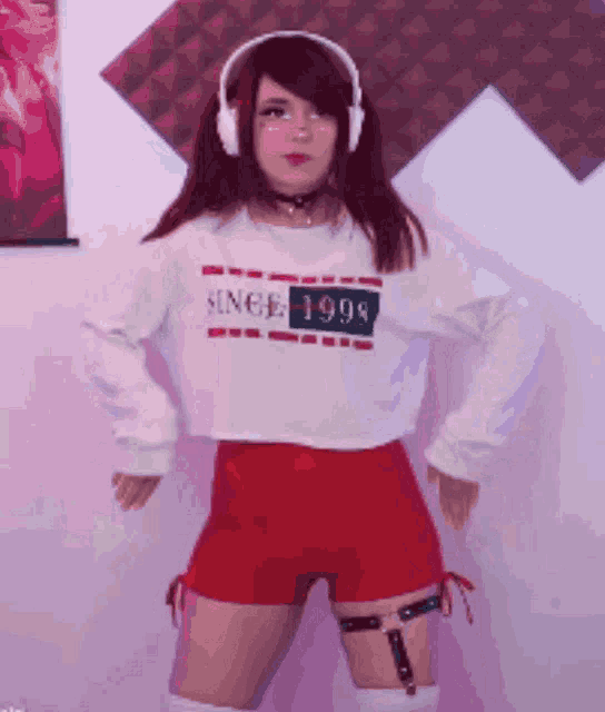 a girl wearing headphones and a white shirt that says since 1998 is dancing