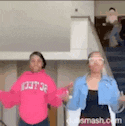 two women are standing next to each other in a room dancing .