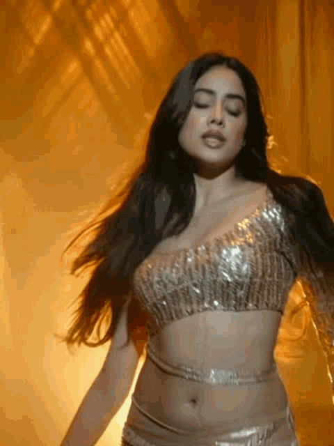 a woman in a crop top is dancing in a dark room .
