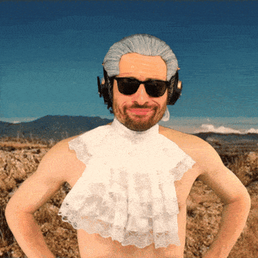 a shirtless man wearing sunglasses and a white lace scarf