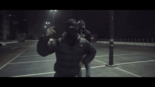 a man wearing a black puma sweatshirt is standing next to another man