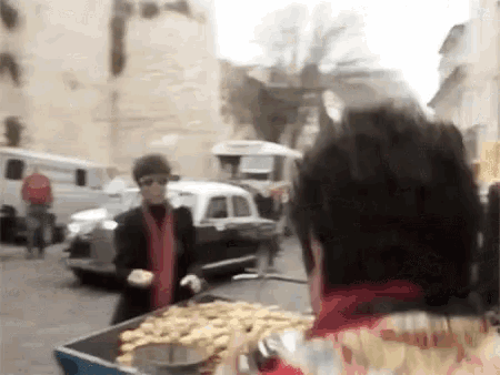a man in a red scarf is standing in front of a cart full of chips