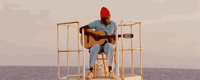 a man is sitting on a boat holding a guitar