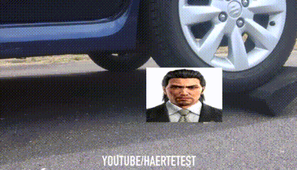 a man in a suit and tie is standing next to a car wheel